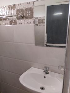 a bathroom with a white sink and a window at Travelhubs Rooms in Kandy