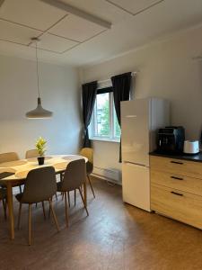 a kitchen and dining room with a table and a refrigerator at Kirkenes town apartments in Kirkenes