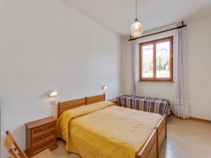 ein Schlafzimmer mit einem Bett und einem Fenster in der Unterkunft Cozy apartment with swimming pool and gym on Lake Trasimeno in Tuoro sul Trasimeno