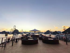 una terraza con mesas y sillas sobre el agua en Garden Legend Cruise, en Ha Long