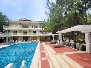 een villa met zwembad en huis bij Spacious Central Davao City Getaway - Spacious Apartment with Shared Pool in Cabaguio