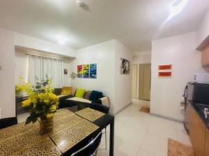 een woonkamer met een tafel en een bank bij Spacious Central Davao City Getaway - Spacious Apartment with Shared Pool in Cabaguio