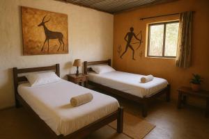 a bedroom with two beds and a picture of a giraffe at Bushman Spoor Backpackers in Soweto