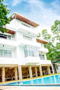a white building with a pool in front of it at Villa TIS in Galle