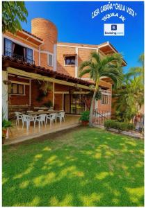 a house with a patio with tables and a palm tree at Casa CABAÑA CHULA VISTA a 5 minutos del centro in Tequila