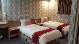 Postel nebo postele na pokoji v ubytování Mei Hua Hotel