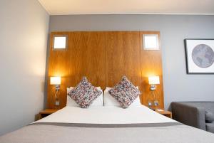 un dormitorio con una cama con dos almohadas. en Ramada by Wyndham Belfast, en Belfast 40 fotos más