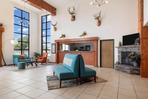 a lobby with blue chairs and a fireplace at Howard Johnson by Wyndham Oacoma Hotel & Suites in Oacoma