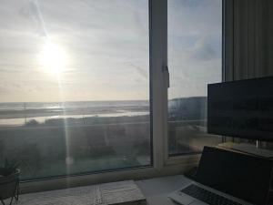 a desk with a laptop and a window with a view of the ocean at Sandylands in Braystones