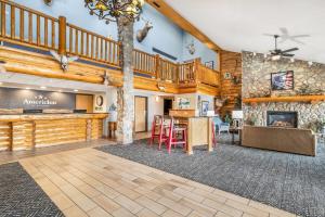 a large living room with a staircase and a fireplace at AmericInn by Wyndham Chamberlain Conference Center in Chamberlain