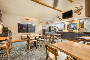 a restaurant with tables and chairs and a kitchen at AmericInn by Wyndham Chamberlain Conference Center in Chamberlain