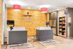 a store with two counters in front of a wooden wall at Microtel Inn & Suites by Wyndham Mont Tremblant in Mont-Tremblant +77 photos