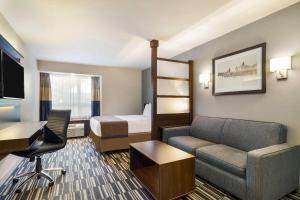 a hotel room with a couch and a bed at Microtel Inn & Suites by Wyndham Mont Tremblant in Mont-Tremblant