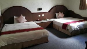 Postel nebo postele na pokoji v ubytování Mei Hua Hotel