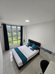 ein Schlafzimmer mit einem Bett und einem großen Fenster in der Unterkunft Ipoh Anderson Condo - 2BR in Ipoh