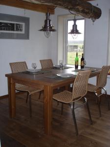 a wooden table with chairs and wine bottles on it at Rotes Haus in Brook