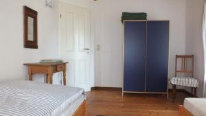 ein Schlafzimmer mit einem blauen Schrank und einem Tisch in der Unterkunft Rotes Haus in Brook