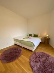 a bedroom with a bed with two purple rugs at Modern 3-room apartment in Kloten