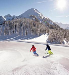 two people are skiing down a snow covered slope at CrazyRoom in Schladming