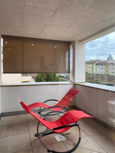 two red chairs in a kitchen with a window at Modern 3-room apartment in Kloten