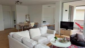 a living room with a white couch and a tv at Modern 3-room apartment in Kloten