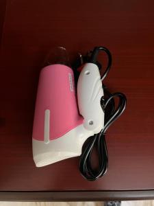 a pink and white appliance hanging on a shelf at Moon hostel in Seeb