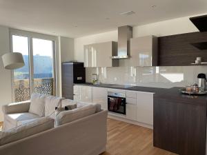 a living room with a couch and a kitchen at Modern 3-room apartment in Kloten