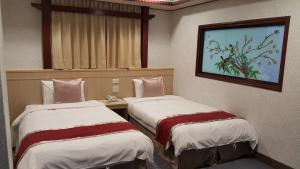Postel nebo postele na pokoji v ubytování Mei Hua Hotel