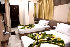 ein Hotelzimmer mit 2 Betten mit Bögen darauf in der Unterkunft Hotel Silver Palace in Haldwani-Kathgodam