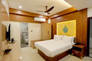 um quarto com uma cama branca e uma casa de banho em Kaizen Residency Trichy em Tiruchchirappalli