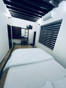 a white bed in a room with a window at Riftha La Banquet in Kannur