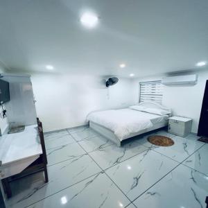 a white bedroom with a bed and a tiled floor at Riftha La Banquet in Kannur