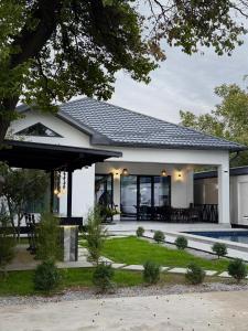 ein Zuhause mit einem großen Fenster und einem Haus in der Unterkunft Дачный Дом in Schymkent