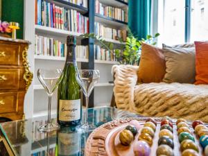a bottle of wine and two glasses on a glass table at Timeless Prague Apartment by House of Huxe in Golčŭv Jeníkov +8 photos