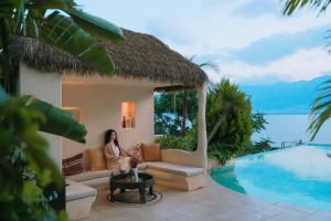 a woman sitting on a couch next to a pool at Dali Heartland Castle VILLA Cliffside Sea View Estate in Dali +140 photos