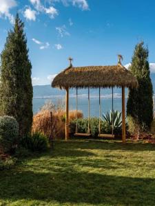 a gazebo with a grass roof on a field at Dali Heartland Castle VILLA Cliffside Sea View Estate in Dali