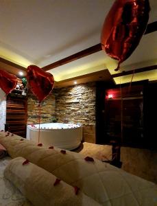 a room with balloons and a bath tub with hearts at Stone Spa Apartman in Sremčica +8 photos