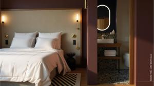 Un dormitorio con una cama y un baño con espejo. en Hotel 2M, The Originals Relais, en Saint-Rambert-sur-Loire 2 fotos más
