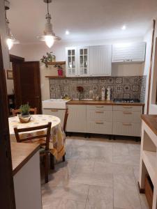 a kitchen with white cabinets and a table in it at Toscana Villa in Snagov