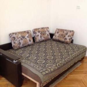 a couch sitting in a room with two pillows at Apartment Downtown in Mukacheve