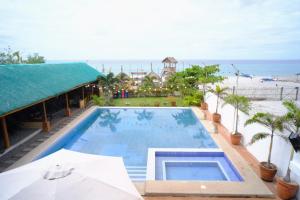 einen Pool mit Sonnenschirm und Strand in der Unterkunft Parasio de Bernal Beach Resort in Cabangan