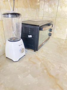 a blender sitting on the floor next to a microwave at Amore Cosy 2 Bedroom Apartment in Mombasa