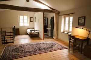 a living room with a table and a rug at Le Refuge de Bruno in Saint-Amans-Soult