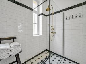 a bathroom with a shower with white tiles at Timeless Prague Apartment by House of Huxe in Golčŭv Jeníkov