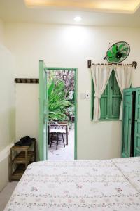 - une chambre avec un lit et une porte donnant sur une terrasse dans l'établissement Năm Ấy Homestay, à Phan Thiết