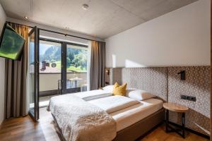 Un dormitorio con una cama grande y una ventana grande en Gästehaus Schneeberger, en Mayrhofen