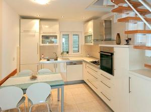 a kitchen with white cabinets and a table and chairs at Apartment Vanja in Tučepi