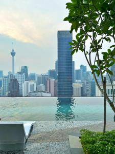 einen Pool mit einer Skyline der Stadt im Hintergrund in der Unterkunft Axon Residence by Perkasa Ikon Homestay in Kuala Lumpur