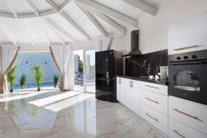 a kitchen with white cabinets and a view of the ocean at וילה מילגרוס - וילה מהממת עם בריכה פרטית in ‘Ein Ya‘aqov