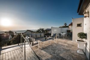 a patio with a couch and a table on a balcony at וילה מילגרוס - וילה מהממת עם בריכה פרטית in ‘Ein Ya‘aqov